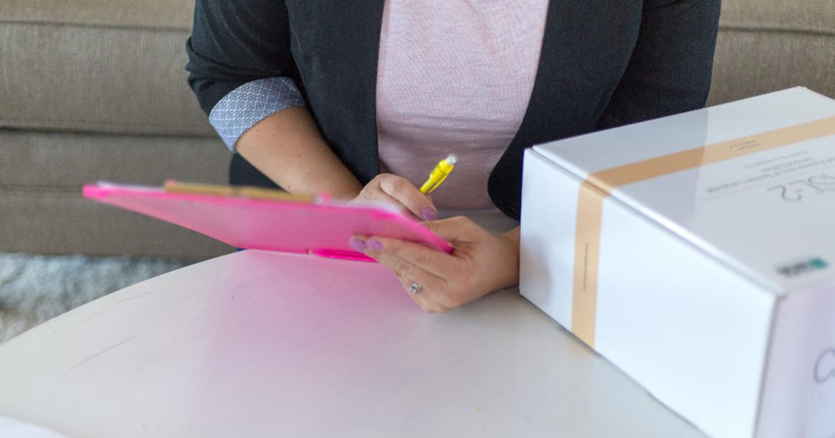 A person filling out a printed assessment form on a clipboard