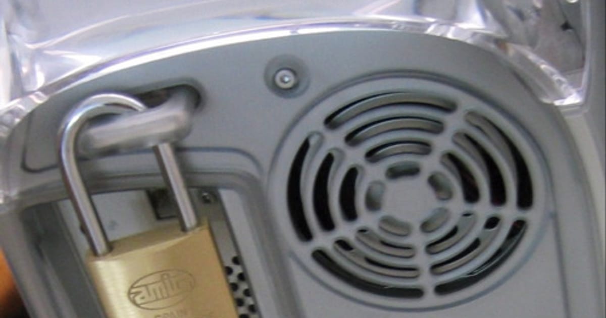 A brass padlock securing a computer, representing data protection